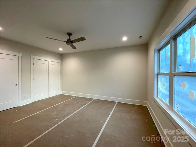 unfurnished bedroom featuring multiple windows, multiple closets, and ceiling fan