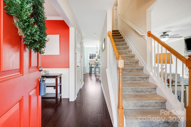 stairway with a textured ceiling, wood-type flooring, and ceiling fan