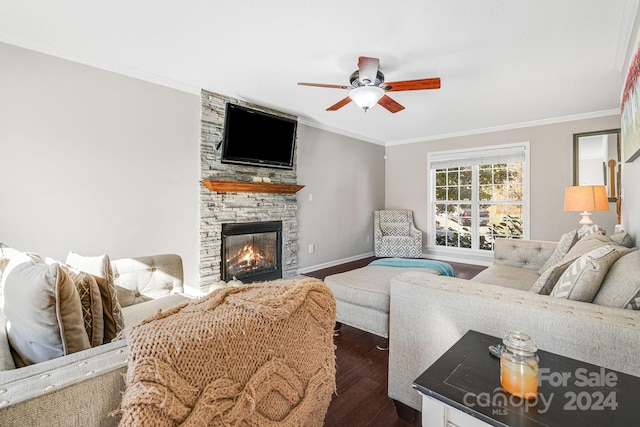 living room with a stone fireplace, ornamental molding, dark hardwood / wood-style floors, and ceiling fan