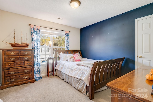 bedroom with carpet and a textured ceiling