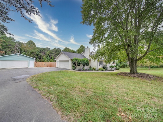 view of front of property with an outdoor structure, a garage, and a front yard