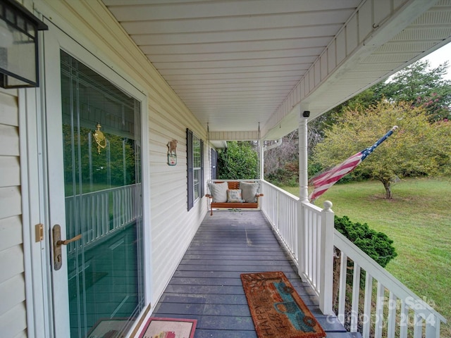 wooden deck with a lawn and a porch