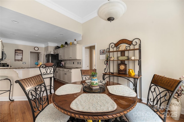 dining space featuring dark wood-type flooring and ornamental molding