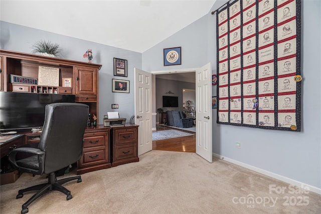 office area featuring lofted ceiling and light colored carpet