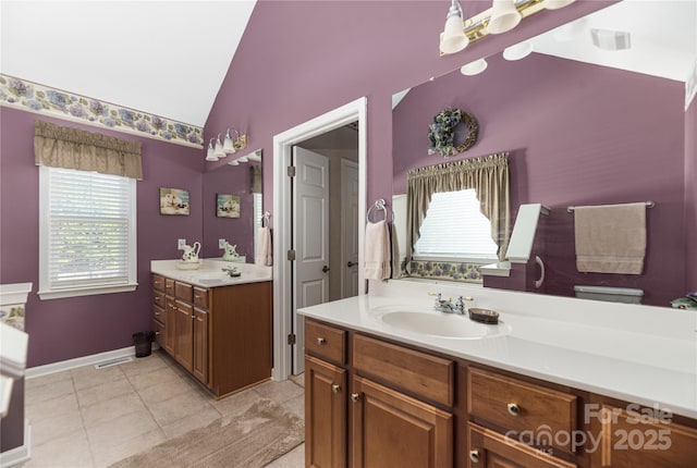 bathroom with tile patterned flooring, vanity, and vaulted ceiling