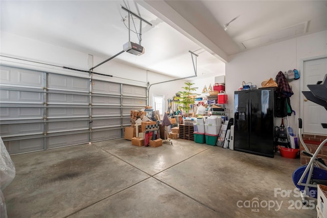 garage with black fridge with ice dispenser and a garage door opener