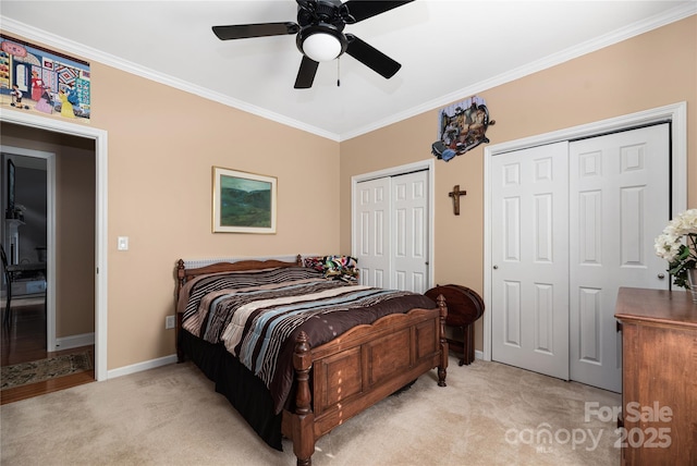 bedroom featuring ceiling fan, two closets, crown molding, and light colored carpet