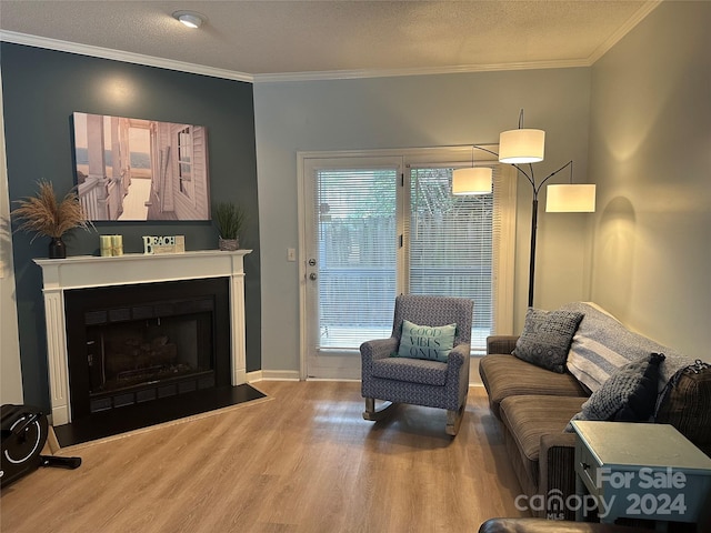 living room featuring hardwood / wood-style flooring, crown molding, and a textured ceiling