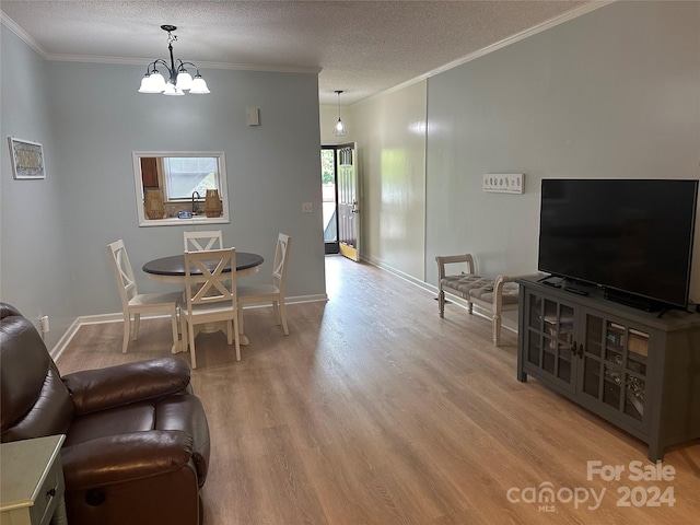 dining area featuring wood-type flooring, a notable chandelier, crown molding, and a textured ceiling