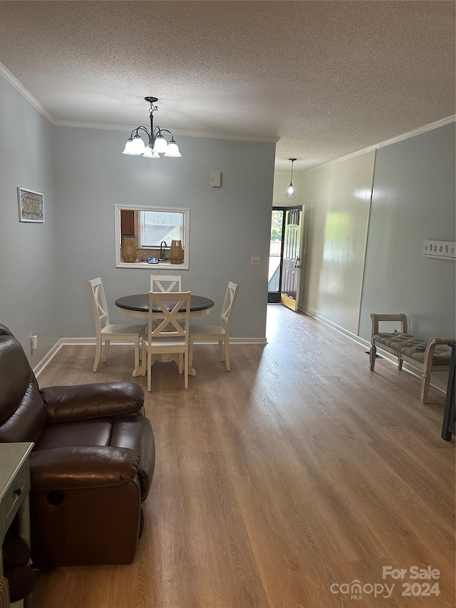 dining space with hardwood / wood-style flooring, crown molding, a chandelier, and a textured ceiling