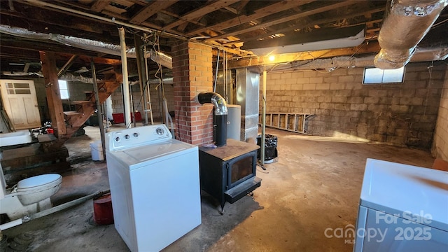 basement with a wood stove and washer / clothes dryer