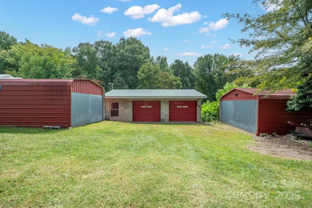 view of pole building featuring driveway and a yard