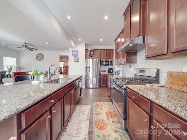 kitchen featuring light stone counters, sink, stainless steel appliances, and light hardwood / wood-style floors