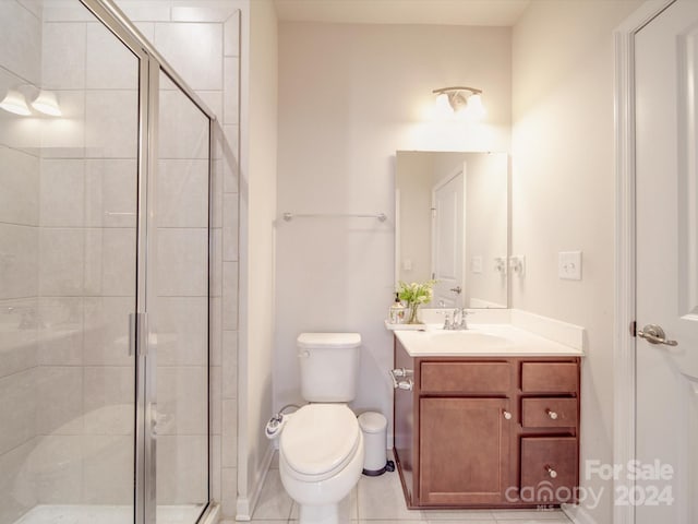 bathroom featuring tile patterned flooring, vanity, toilet, and walk in shower