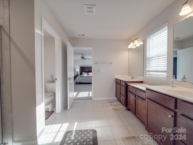 bathroom with ceiling fan, tile patterned floors, toilet, a shower with door, and vanity