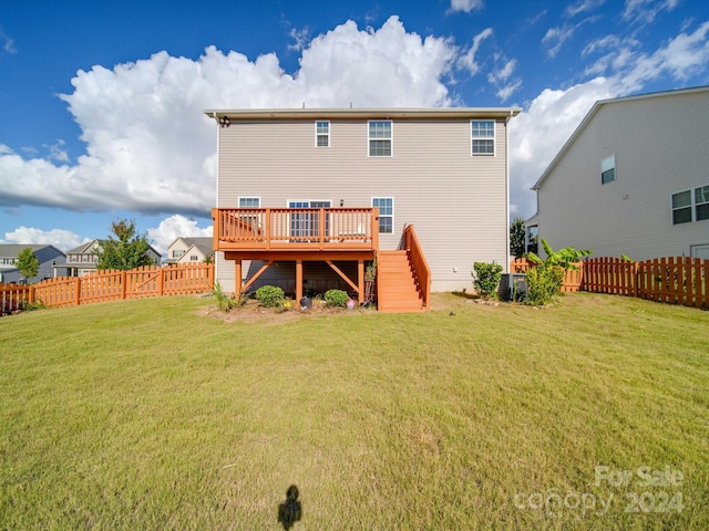 rear view of house with a lawn and a wooden deck