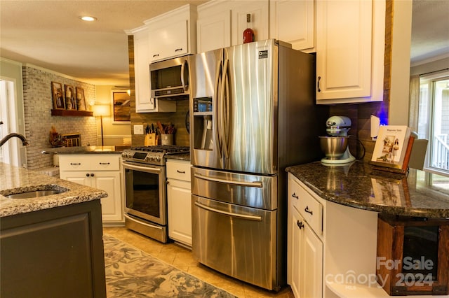 kitchen featuring white cabinetry, a wealth of natural light, stainless steel appliances, and sink