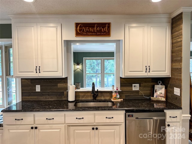 kitchen with dishwasher, dark stone counters, white cabinetry, and sink