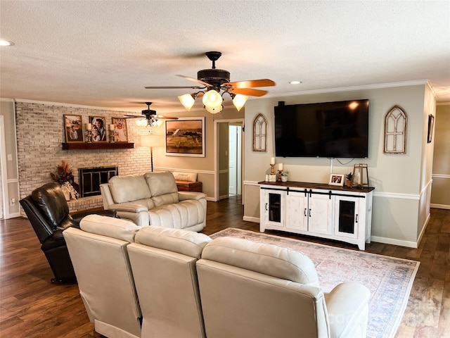 living room featuring ceiling fan, dark hardwood / wood-style flooring, a textured ceiling, and a brick fireplace