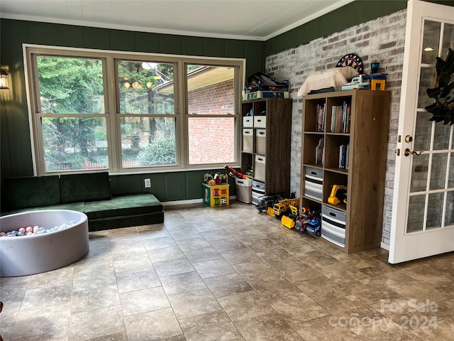 interior space with crown molding, plenty of natural light, and a bathtub