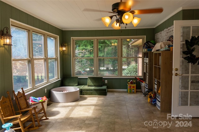 sunroom featuring ceiling fan and plenty of natural light