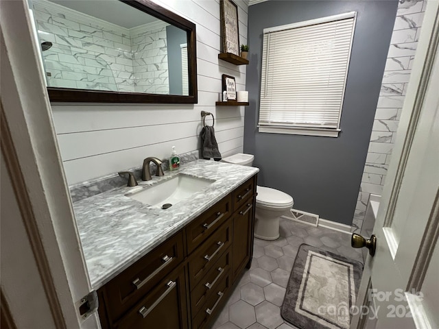 bathroom featuring a shower, toilet, crown molding, and vanity