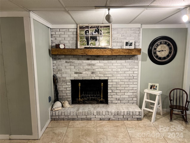 room details featuring a fireplace, a drop ceiling, and tile patterned floors