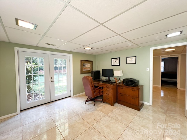 tiled office space with a drop ceiling and french doors