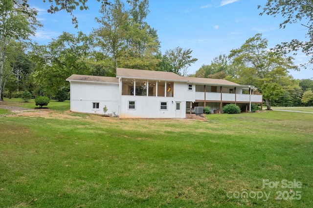 back of property featuring central air condition unit, a sunroom, and a yard