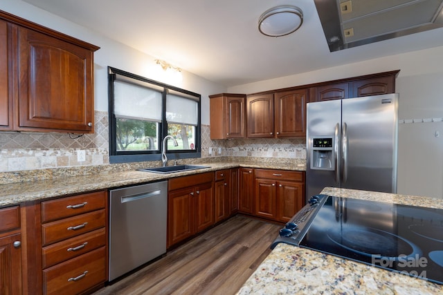 kitchen with stainless steel appliances, sink, light stone counters, dark hardwood / wood-style flooring, and decorative backsplash