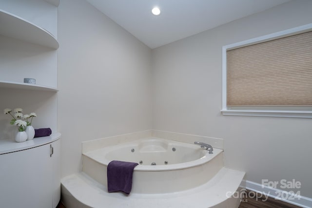 bathroom with a washtub, lofted ceiling, and wood-type flooring