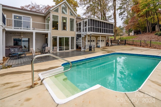 view of swimming pool with a patio area and a sunroom