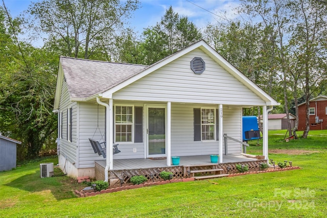 view of front of home featuring a front lawn, covered porch, and cooling unit