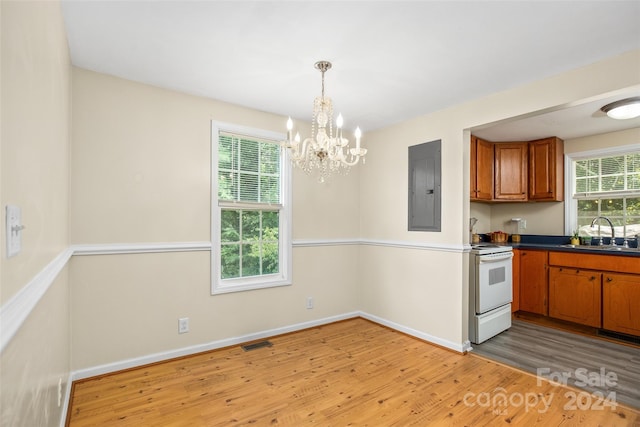 kitchen with a notable chandelier, sink, white electric range oven, hardwood / wood-style flooring, and electric panel