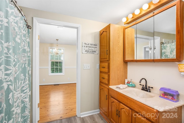 bathroom featuring hardwood / wood-style floors, a chandelier, and vanity