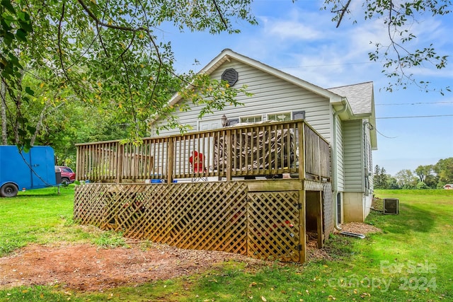 back of property with a lawn, central AC, and a deck