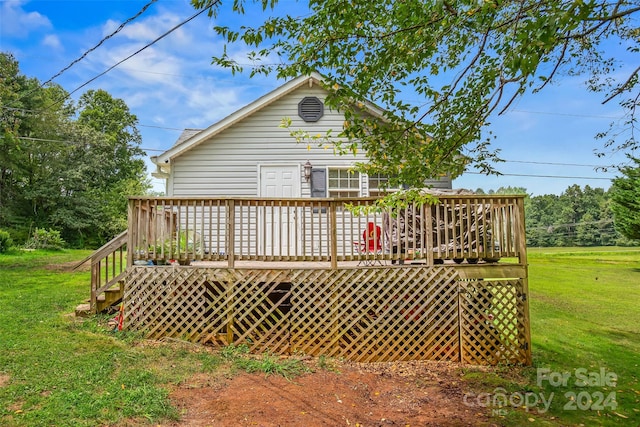 back of house featuring a wooden deck and a lawn