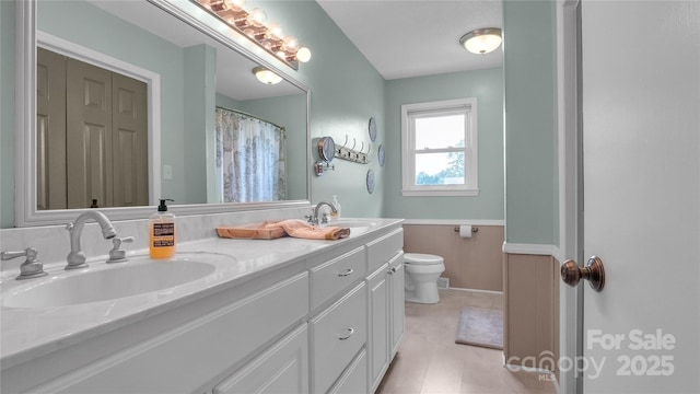 bathroom featuring wood walls, vanity, and toilet