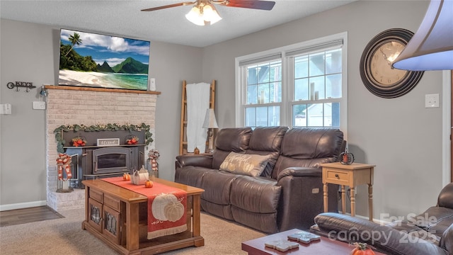 living room featuring a fireplace, a textured ceiling, light colored carpet, and ceiling fan