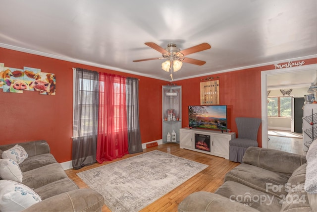 living room with ceiling fan, baseboards, ornamental molding, and hardwood / wood-style floors