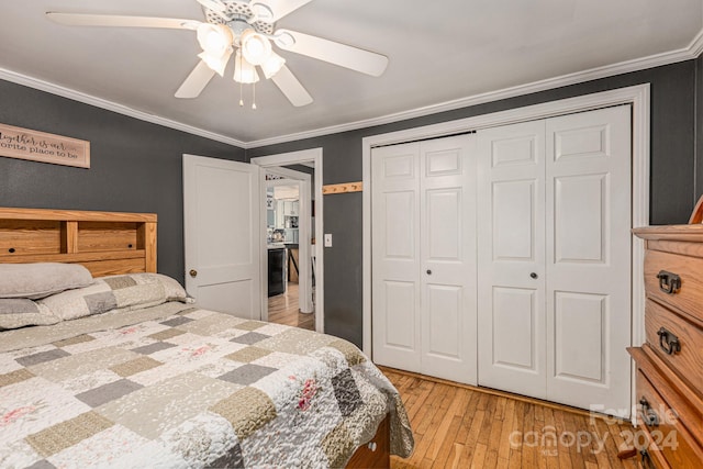 bedroom with ceiling fan, light wood-type flooring, crown molding, and a closet