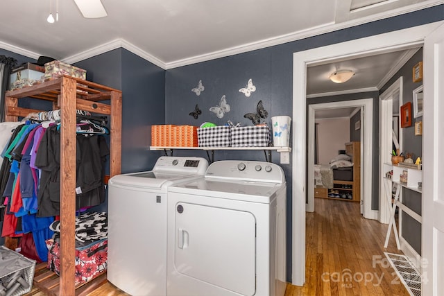 laundry area with crown molding, washer and dryer, ceiling fan, and light hardwood / wood-style flooring