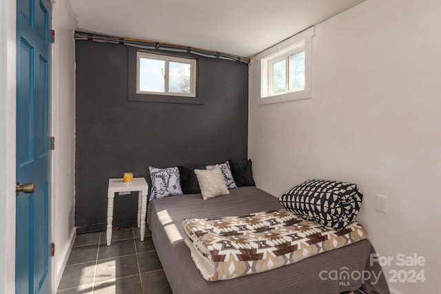 bedroom featuring dark tile patterned flooring and multiple windows