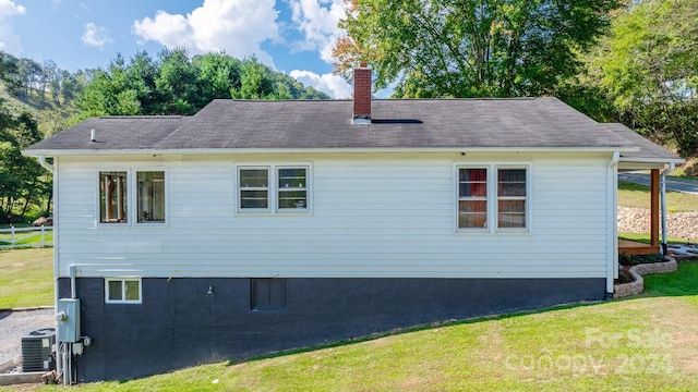 view of home's exterior with a yard and central AC