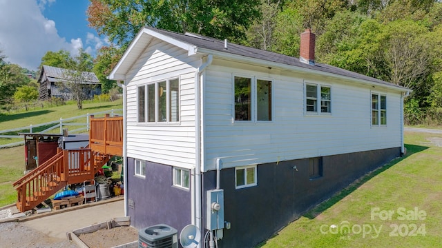 view of property exterior featuring central AC unit and a yard