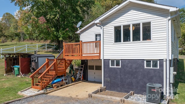 view of front facade with a deck, a storage shed, and central AC