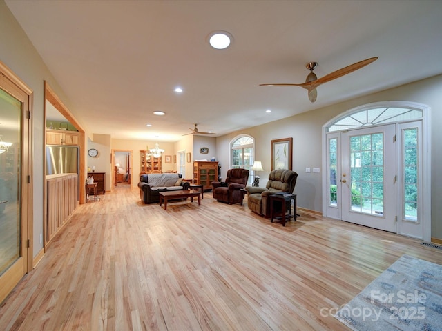 living room featuring recessed lighting, visible vents, light wood-style flooring, and ceiling fan with notable chandelier