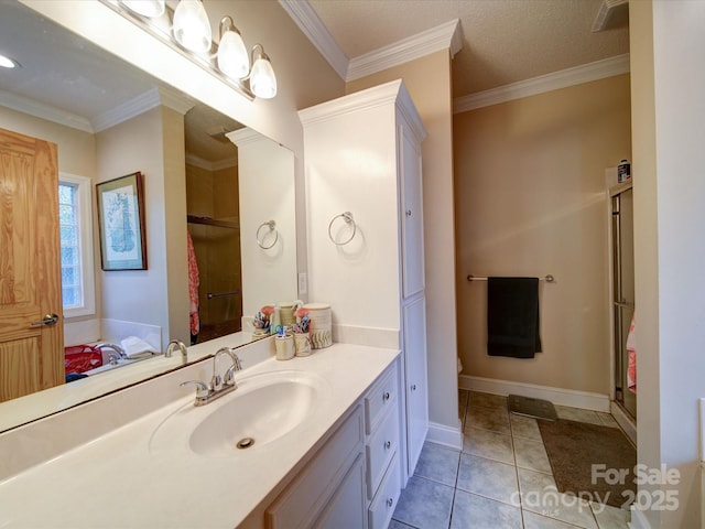 full bath with tile patterned flooring, vanity, baseboards, a shower with door, and crown molding