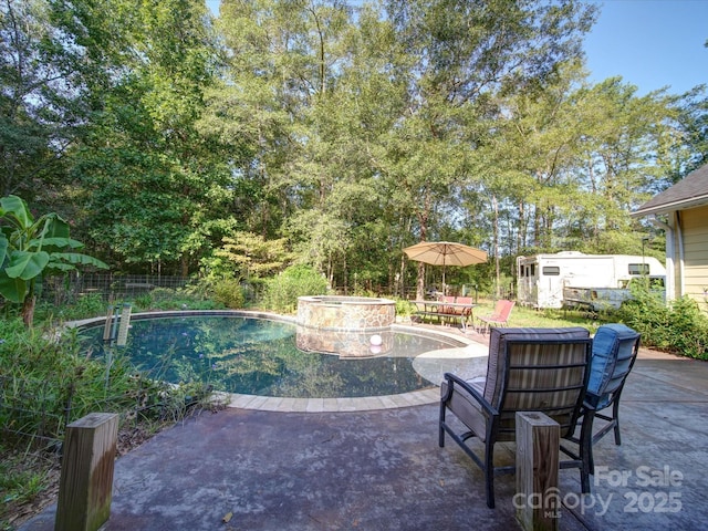 view of pool with a fenced backyard, an outdoor structure, a pool with connected hot tub, a storage unit, and a patio area