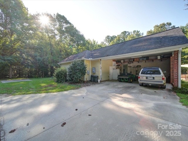 view of front of house featuring an attached garage, brick siding, driveway, roof with shingles, and a front yard